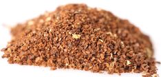 a pile of ground spices on a white surface