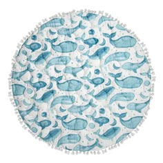 a round blue and white rug with whale designs on it