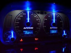 the dashboard of a car is lit up with blue lights and digital numbers on it