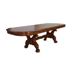 a large wooden table with carved legs and an oval shaped center piece on one end