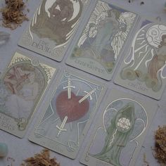 four tarot cards with angels on them sitting next to some brown shavings