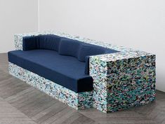 a blue couch sitting on top of a hard wood floor next to a white wall