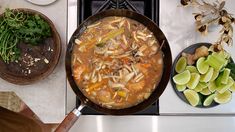 a pan filled with food sitting on top of a stove next to other cooking utensils