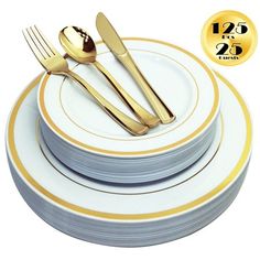 a stack of plates with gold forks and spoons