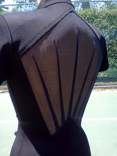 the back of a dress on display in front of a tennis court