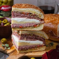 two sandwiches stacked on top of each other next to olives