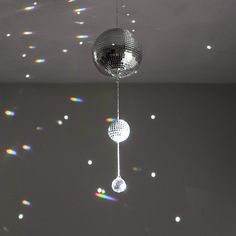 a disco ball hanging from the ceiling in a room with light spots on the wall