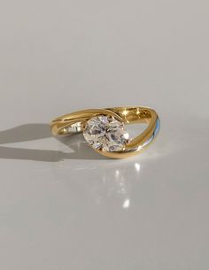 a gold ring with a white diamond in the middle