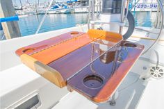 the inside of a sailboat's cockpit with water and boats in the background