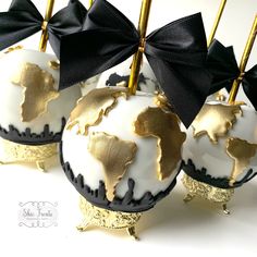 four gold and white globe ornaments with black bows