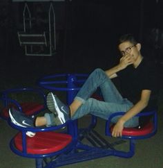 a man sitting on top of a red and blue chair