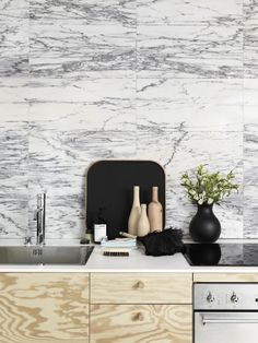 a kitchen counter with vases and other items sitting on it's side, next to a sink