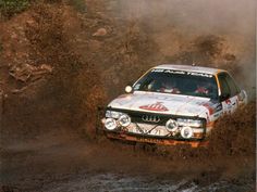 a white car driving through mud in the dirt