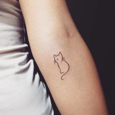 a small cat tattoo on the arm