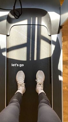 a person standing on a treadmill with their feet in the air and there is a sign that says let's go