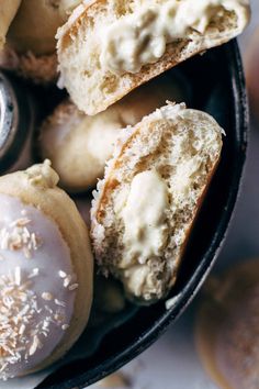 doughnuts with white icing and sprinkles in a black bowl