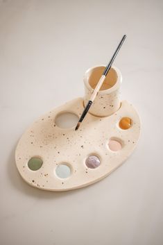 a paint palette and brush on a white tray