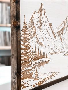 a wooden frame with a mountain scene drawn on it