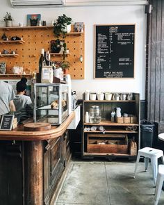 a man working behind the counter in a coffee shop with menus on the wall