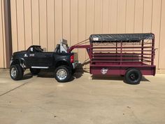 a truck with a trailer attached to it parked in front of a building next to a wall