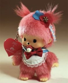 a pink teddy bear with a red heart on it's chest and a bow tie around its neck