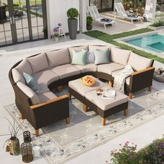 an outdoor living area with couches and tables next to a swimming pool in the background