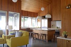 a living room filled with furniture next to a kitchen and dining room table in front of a window