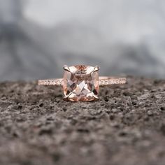 an orange diamond ring sitting on top of a rock