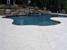 an outdoor pool with water features and landscaping