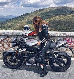 a woman sitting on top of a motorcycle