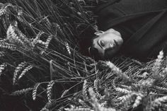 black and white photograph of a man laying in the grass