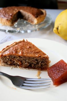 a piece of pie sitting on top of a white plate next to a knife and fork