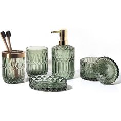 green glass bathroom accessories including soap dispenser, toothbrush holder and cup