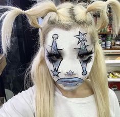 a girl with long blonde hair and face painted like a unicorn is looking at the camera