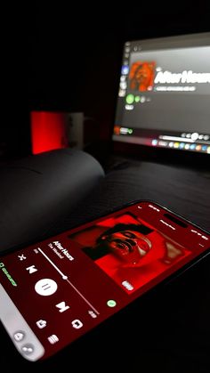 a cell phone sitting on top of a table next to a computer monitor and keyboard