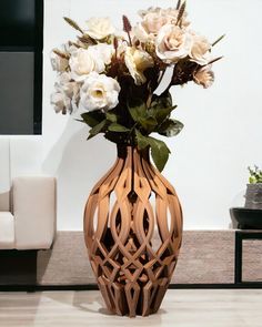 a vase filled with white flowers sitting on top of a wooden table next to a couch