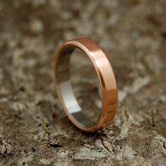 a wedding ring sitting on top of a stone surface with no one in the photo