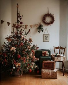 a living room with a christmas tree in the corner and presents on the floor next to it