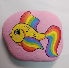 a painted rock with a rainbow fish on it