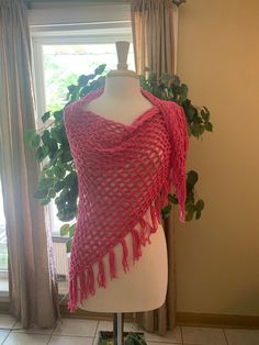 a mannequin wearing a pink shawl with tassels on it's shoulders