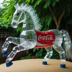 a plastic horse made to look like a coke cola bottle sitting on top of a table