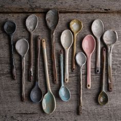 old spoons lined up on a wooden table