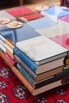 a stack of books sitting on top of a red rug