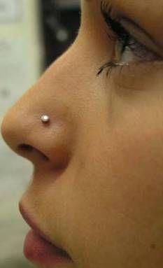 a close up of a person with a nose ring on their nose and an ear piercing