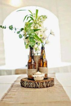 three bottles with flowers in them sitting on a table