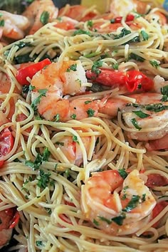 pasta with shrimp, tomatoes and parsley in a bowl