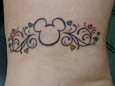 a small tattoo on the side of a woman's stomach with hearts and mickey mouse