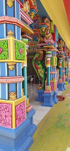 colorfully painted columns and pillars line the walkway at an amusement park or theme park