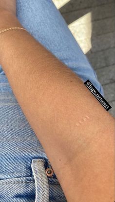 a person wearing a bracelet with a black sticker on it's left arm