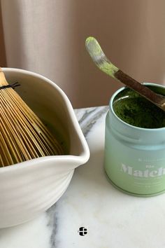 there is a green powder in a bowl and a whisk on the table